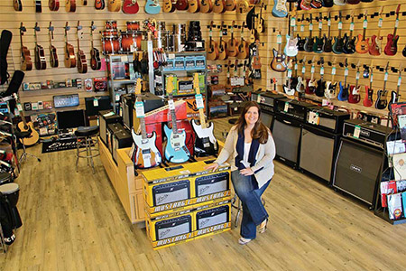 Lauren in room filled with Guitars